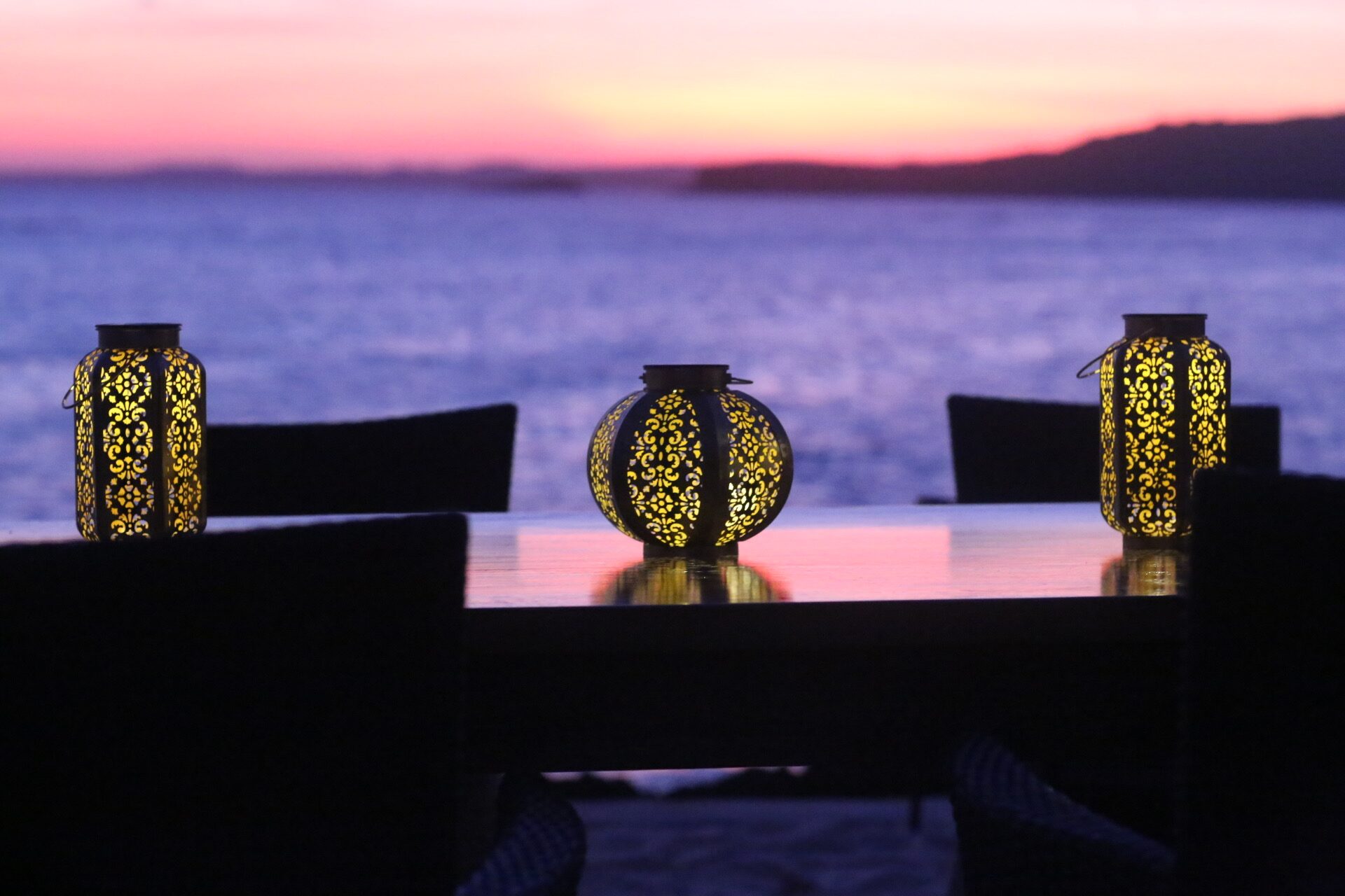 A long table set for dinner at sunset overlooking the sea